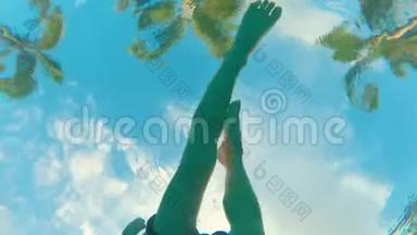 从棕榈树的游泳池底部看风景，还有一个小孩在镜头前游泳